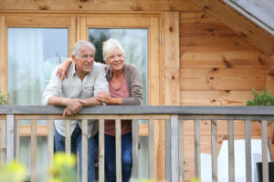 A couple on the porch of their log cabin.