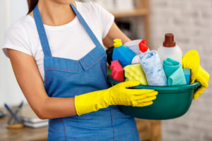 Woman with cleaning supplies.