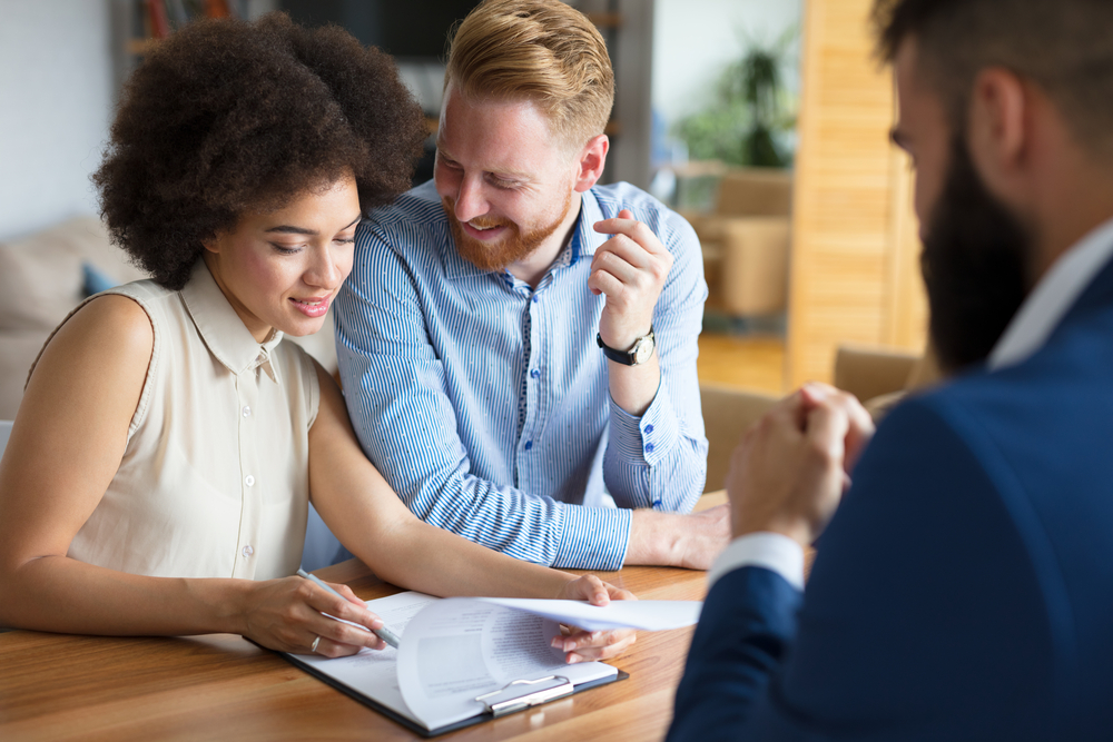 A couple talks with a real estate agent