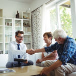 real estate agent sitting down with couple