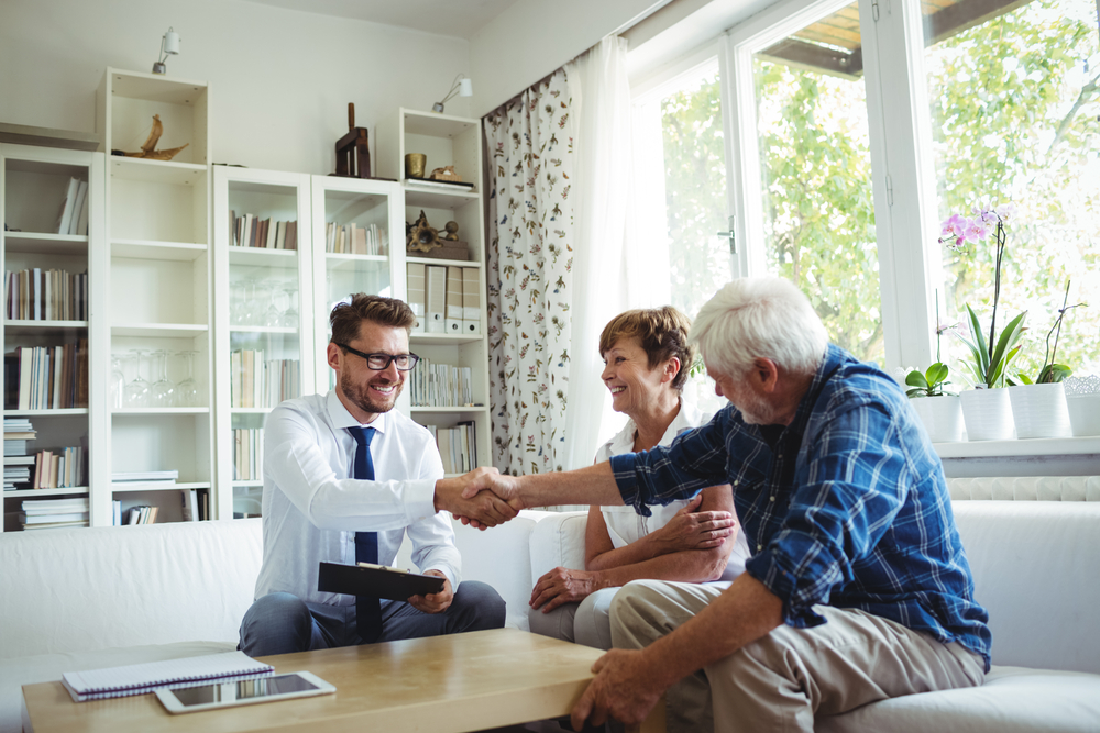 real estate agent sitting down with couple